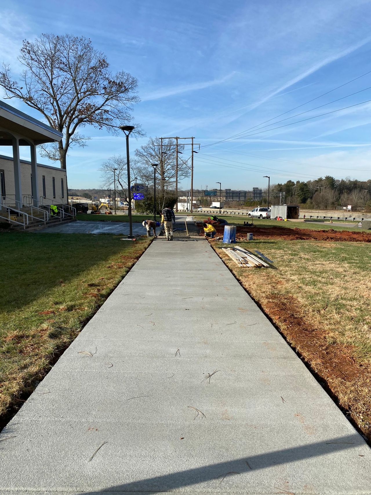 Freshly poured concrete sidewalk beside a lawn